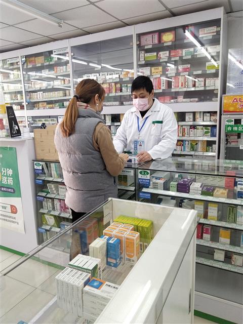 疫情防控時期，魏駿在藥店為顧客提供藥學(xué)服務(wù)。