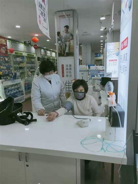 魏雪鴻為顧客測量血壓。